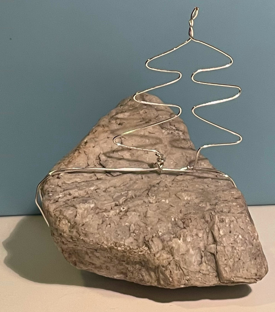 Ein Drahttannenbaum auf einem weißen Stein